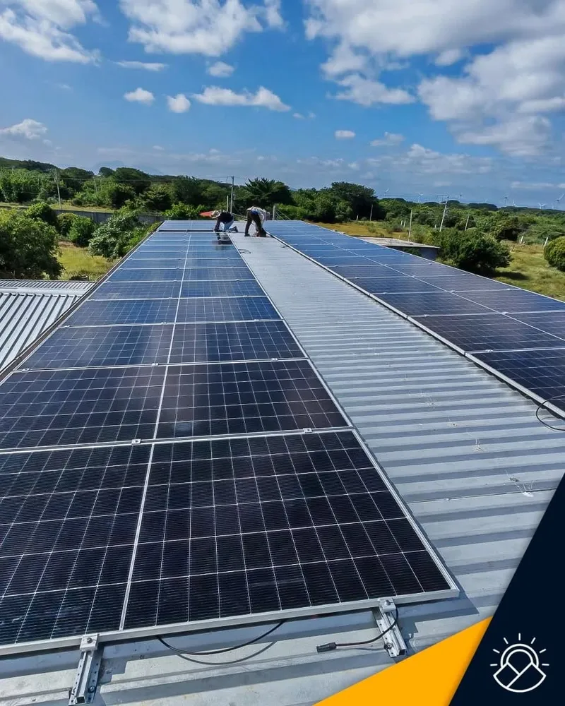 Hileras de paneles solares sobre el techo de una nave, con técnicos de A&N trabajando