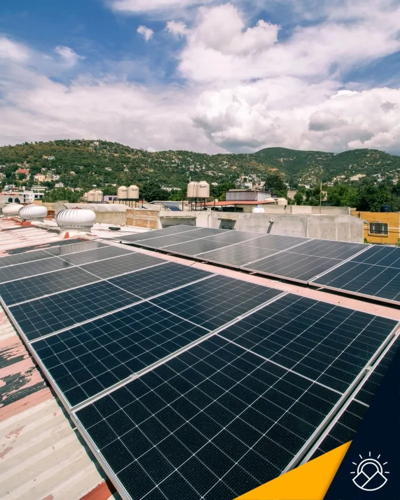 Paneles solares instalados por A&N en un techo, con cerros de Oaxaca al fondo