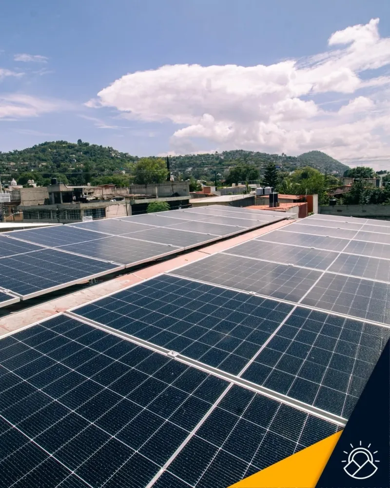 Paneles solares instalados en una azotea con vista a los cerros