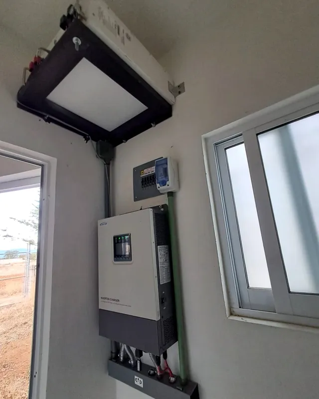 Inversor cargador y centro de carga instalados en el muro de un cuarto
