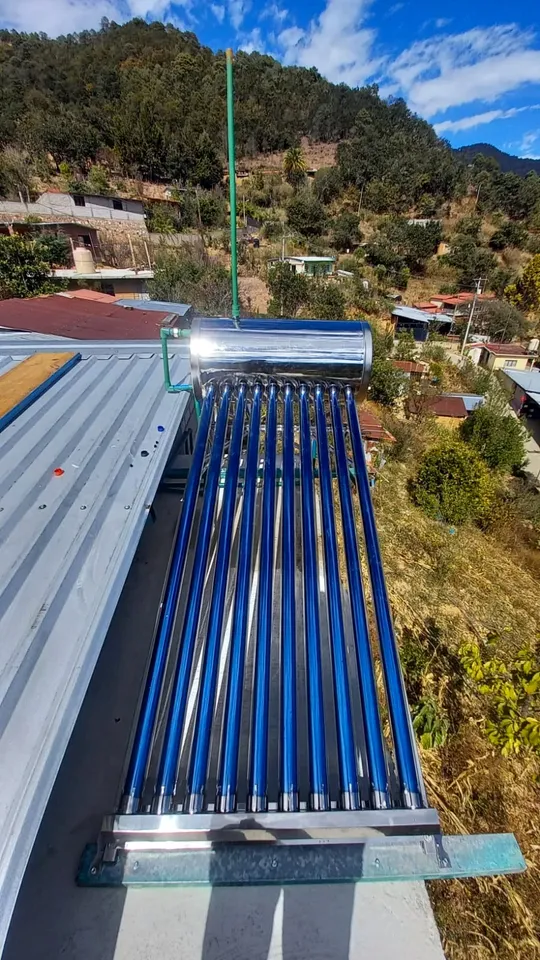Calentador solar instalado en un techo de lámina en una ladera