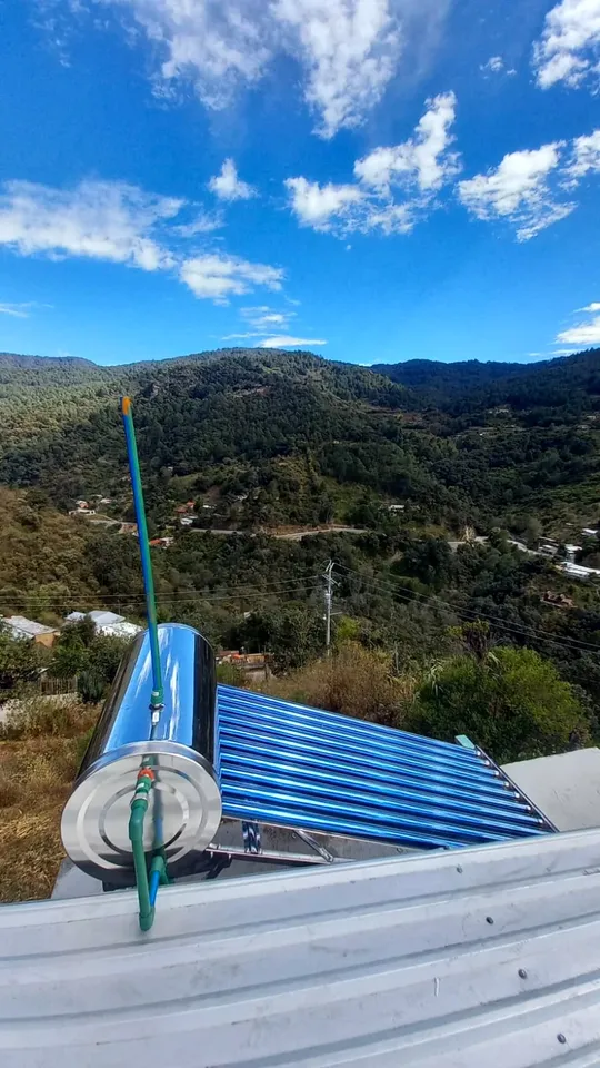 Calentador solar de tubos en un techo con vista a la sierra