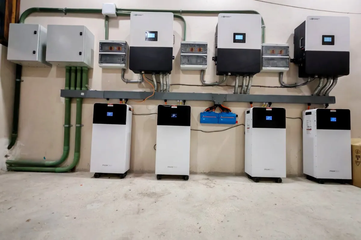 Cuarto de equipos con varios inversores y baterías instalados en muro