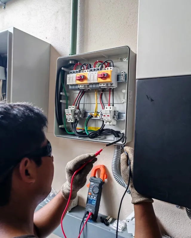 Técnico midiendo conexiones en un tablero de protecciones