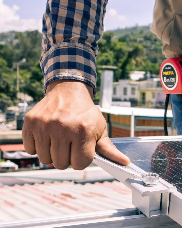 Técnico ajustando la sujeción de un panel solar con una llave