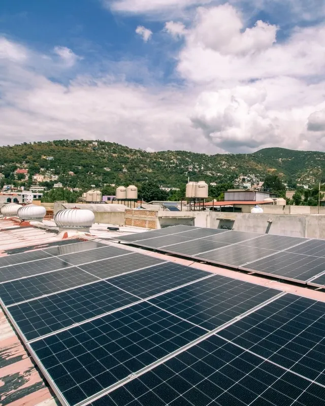 Paneles solares sobre techo de lámina con cerros al fondo