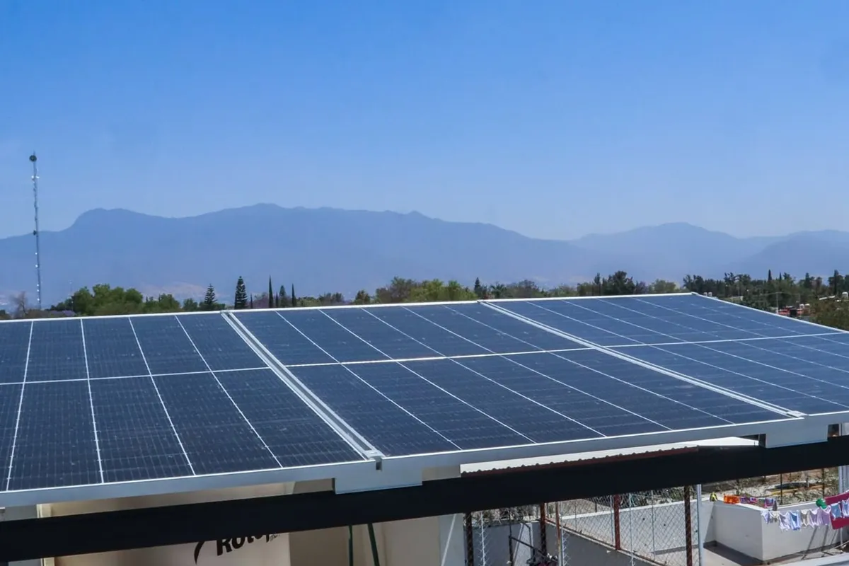 Estructura de paneles solares sobre un tinaco con montañas al fondo