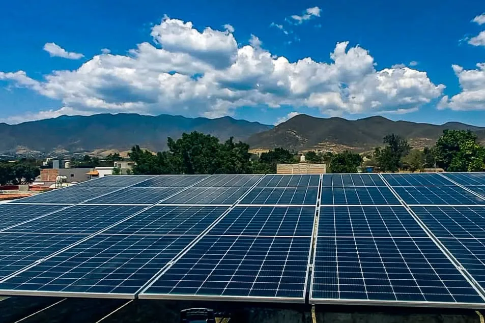 Paneles solares en azotea con montañas y cielo despejado